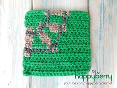 a green crocheted dishcloth with a design on it