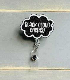 "Black Cloud Energy Badge Reel is a cute and funny badge reel for Nurses. This Bad Luck ID Holder will bring many laughs for sure!! Perfect for anyone who wears a badge!! Makes a great funny gift for those of us who just bring all the bad luck.  Item is 2\" wide and attached to your choice of an Alligator Swivel clip or Slide on badge Reel with a low profile self-fastener. Easy to switch out!!   Face plate only option is available to be able to switch out badge reels. It includes 2 pieces of low Personalized Black Badge Reel For Personal Use, Themed Black Badge Holders For Gift, Novelty Black Badge Reel For Gift, Themed Black Badge Reel For Gifts, Themed Black Badge Reel As A Gift, Novelty Black Badge Reel Customizable, Themed Black Badge Reel For Gift, Customizable Novelty Black Badge Reel, Themed Black Badge Reel Gift