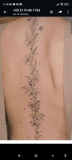 the back of a woman's body with flowers and leaves tattooed on her left side