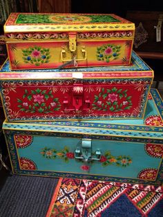 three brightly painted trunks stacked on top of each other