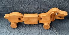 a wooden toy dog sitting on top of a bed