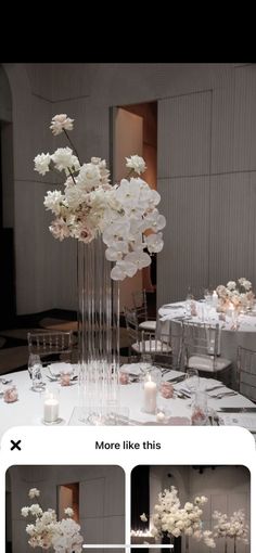 a tall vase filled with white flowers sitting on top of a table covered in candles