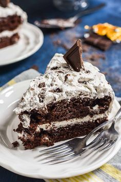 a piece of chocolate cake on a plate with a fork in front of the slice