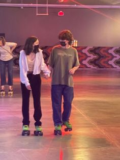 two people on skateboards are talking to each other in the middle of a room