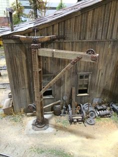 an old wooden building with various tools on the ground