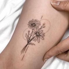 a woman's arm with daisies tattoo on it