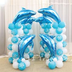 blue and white balloons with dolphins in the middle are arranged on top of each other