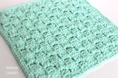 a green crocheted blanket sitting on top of a white table