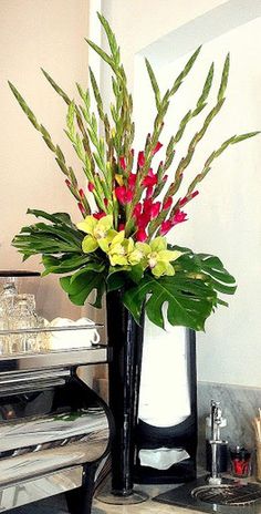 a vase filled with flowers sitting on top of a counter next to an open piano