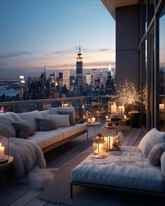 a living room filled with furniture and candles on top of a balcony overlooking the city