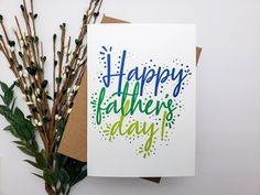 a card that says happy father's day on it next to some flowers and twigs