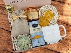 a gift box with orange slices, honey, and other items in it on a wooden table