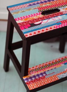 a small wooden stool with colorful fabric on it