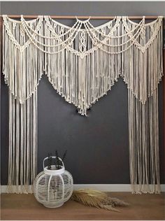 a white wall hanging on the side of a gray wall next to a basket and plant