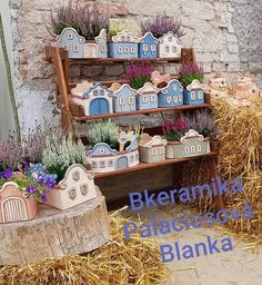 there are many small houses on display in the hay bales with plants growing out of them