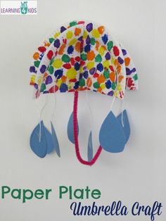 a paper plate umbrella craft is hanging on the wall with text that reads paper plate umbrella craft