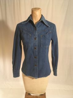 "vintage 1970s women's western denim shirt Brittania Sportswear cotton blue jean button up front 2 bust pockets long sleeve/button cuff yoke hem good vintage condition, light wear labeled size 5, very petite, see below measures, lying flat, shoulder-  13 1/2\" sleeve-20 1/2\" chest-16\" waist-14\" hem-16\" length from top at neck seam below collar-22\"" Fitted Collared Denim Jacket With Pockets, Fall Cotton Fitted Shirt, Fitted Cotton Shirt For Fall, Long Sleeve Medium Wash Shirt For Fall, Non-stretch Long Sleeve Denim Tops, Fitted Collared Denim Jacket In Denim Blue, Fitted Collared Denim Jacket With Button Closure, Fitted Collared Denim Jacket, Fitted Tops With Pockets For Fall