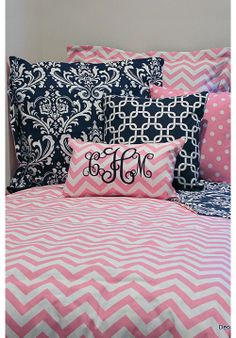 pink and blue bedding with monogrammed pillowcases on the headboard