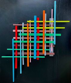 an abstract piece of art made out of colored sticks