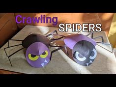 two paper mache spiders sitting on top of a table