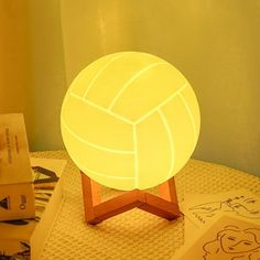 a lit up volleyball ball sitting on top of a table next to some other items