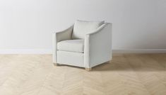 a white chair sitting on top of a hard wood floor next to a wall in an empty room