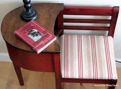 a chair with a book on top of it next to a lamp and a wooden table