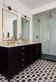 a bathroom with black and white tile flooring and gold fixtures on the sink vanity