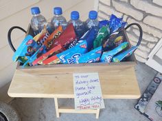 a wooden box filled with lots of candy and water bottles next to a sign that says thank you