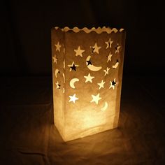 a small paper bag with stars and moon on it in the dark, lit up