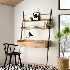 a desk with two shelves and a chair in front of it on a black and white rug