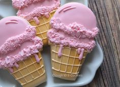 three ice cream cones with pink icing on a plate