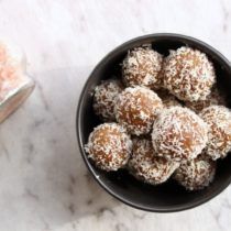 a bowl filled with powdered sugar next to a jar of sea salt on a marble surface