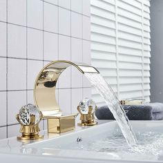 a faucet with water running from it in a bathtub next to a white tiled wall