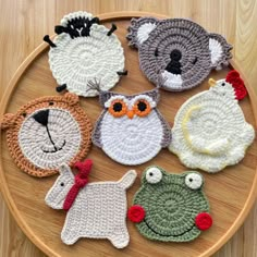 six crocheted animals sitting on top of a wooden table