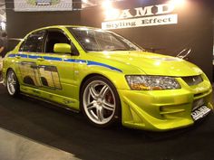 a yellow car is on display at an auto show