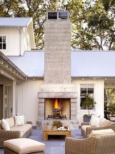 a fire place sitting in the middle of a living room next to a patio with furniture