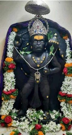 the statue is decorated with flowers and garlands