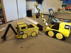 two construction vehicles that are sitting on the floor