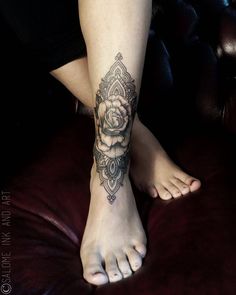 a woman's foot with a rose tattoo on her left leg and an intricate design