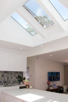 an open kitchen and living room with skylights