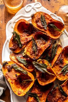 roasted sweet potatoes with sage leaves on a white plate