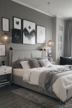 a bedroom with gray walls and pictures on the wall above the bed, along with two lamps