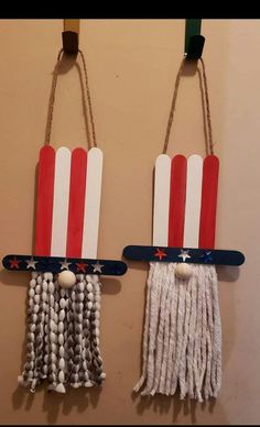 two red, white and blue decorations hanging on the wall with string attached to them