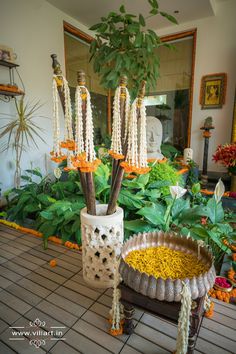 a potted plant with flowers and beads hanging from it's sides in front of a mirror