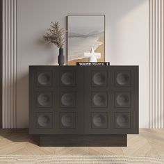 an empty room with a black cabinet and vase on the sideboard next to it