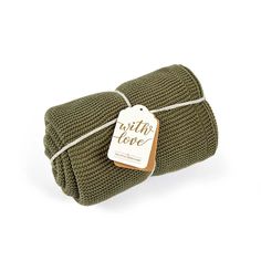 the green knitted blanket has a tag that says wild love on it and is tied up