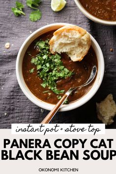 two bowls filled with black bean soup on top of a purple table cloth next to bread and cilantro