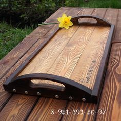 a wooden cutting board with a yellow flower on it