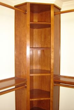 an empty closet with wooden shelves and white walls